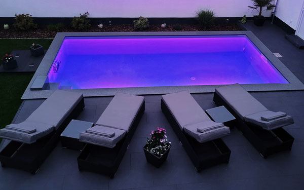 Rechteckpool bei Nacht mit zwei Unterwasserscheinwerfern